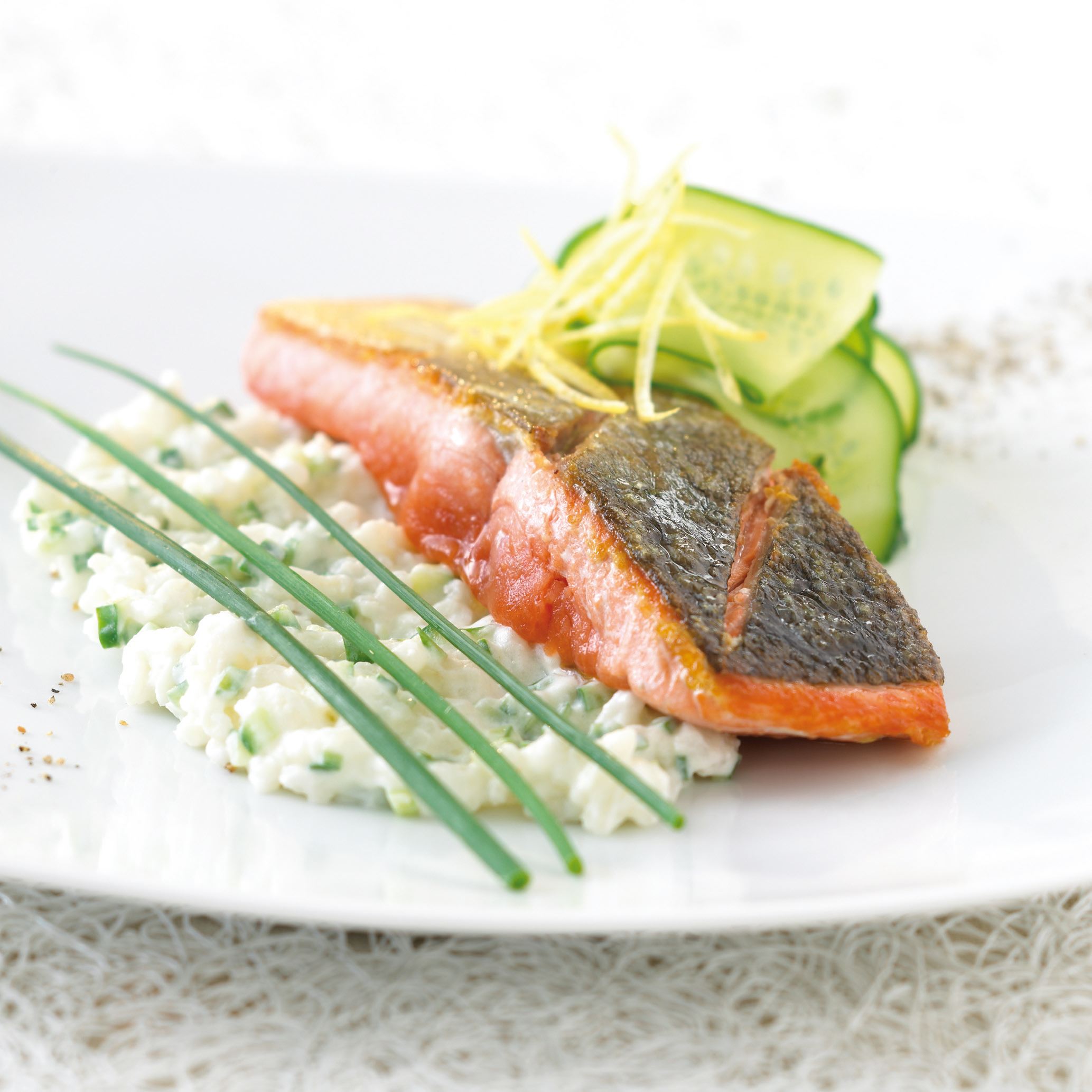 Auf der Haut gebratener Lachs an cremigem Gurkenrisotto